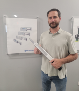 FPE Automation's Scott Massie won PHD Partner of the Month award for this innovative application. Here, he holds a much smaller ECV electric cylinder than the one in this article.